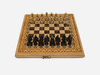 Folding chess board in pale wood with brown marbled epoxy squares, a carved gothic border and figural wooden pieces set up for play