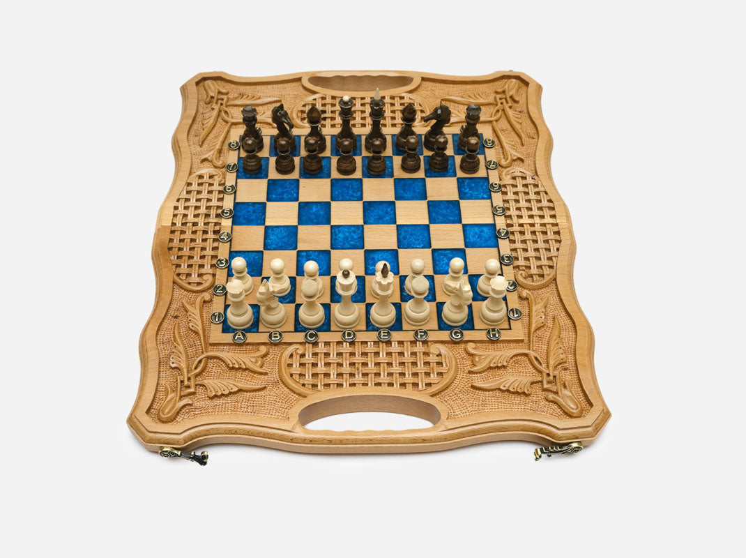 Light beechwood folding chess board with royal-blue epoxy squares and wooden Staunton pieces set up for play