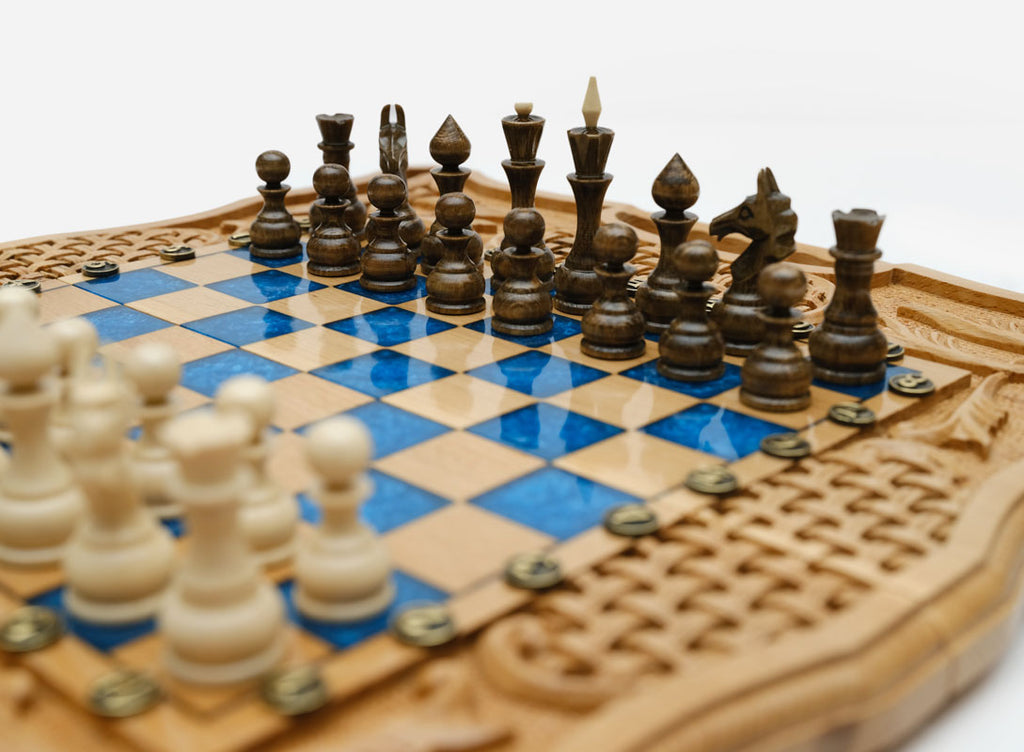 Angled view of the blue epoxy folding chess set with carved basket-weave panels