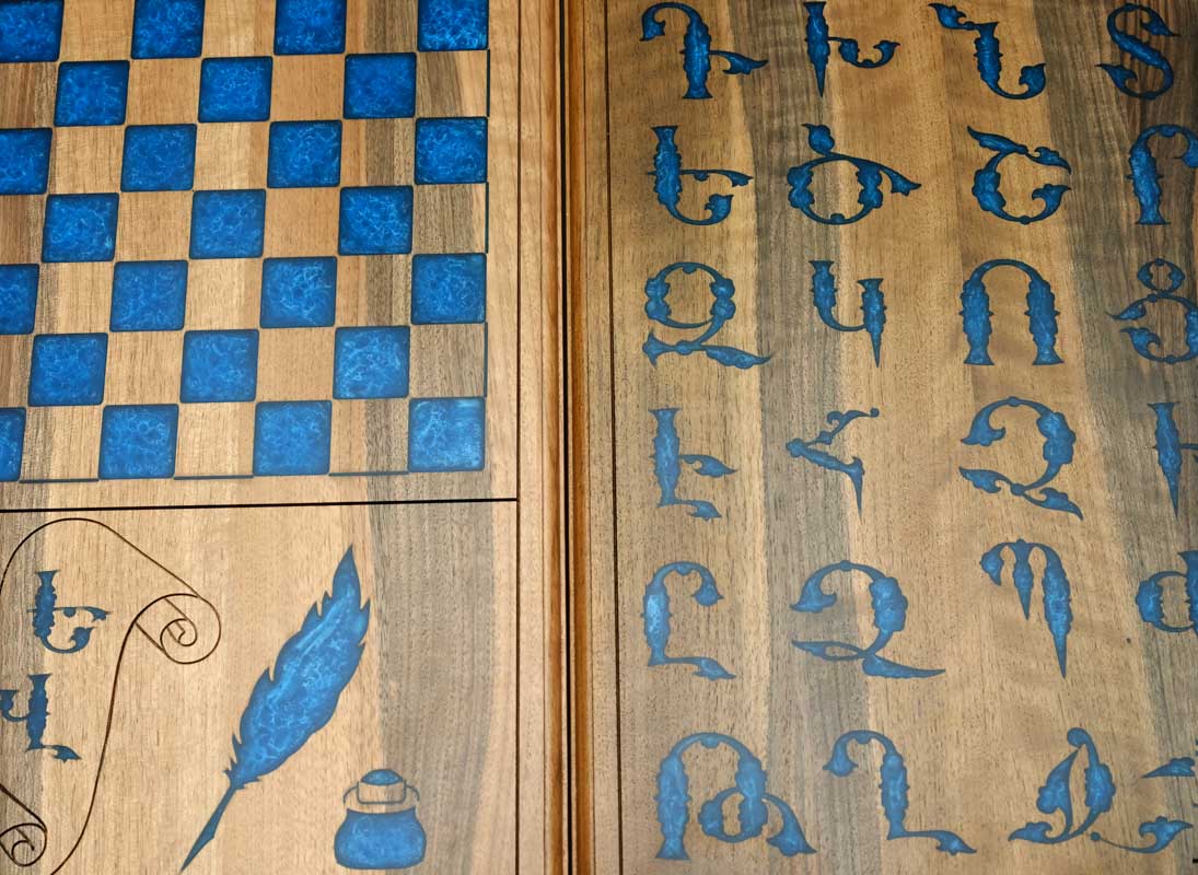 Close-up of the blue epoxy Armenian letters on the walnut surface