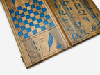 The backgammon board opened to show the playing points and carved rosettes