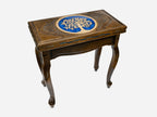 The table shown closed, revealing a carved Tree of Life medallion on top