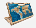 Folding backgammon board with a world map - wooden continents set in swirling blue and teal epoxy oceans - standing open with a carved carry handle
