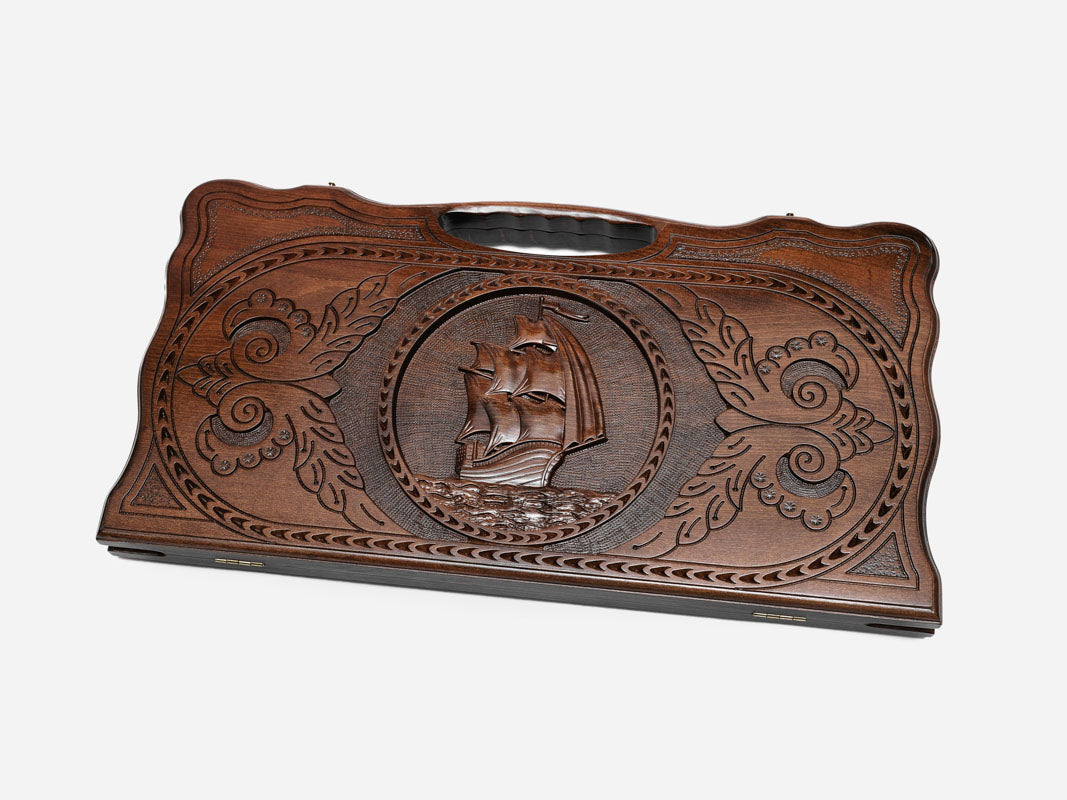 Carved beechwood backgammon board with a sailing ship in a medallion, propped open