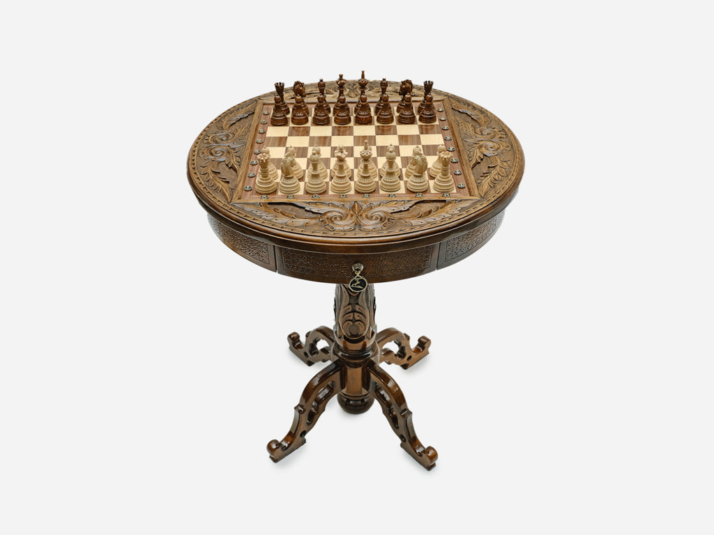 Hand-carved round wooden chess table with a full chess set arranged on the board