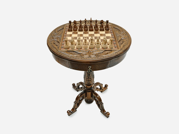 Hand-carved round wooden chess table with a full chess set arranged on the board