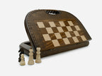 Round-topped folding chess and backgammon board standing open, showing the chess face and carry handle, with wooden pieces in front