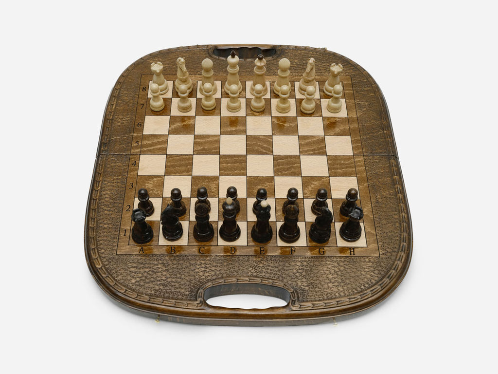 The folding chess-backgammon board standing with its rounded top and carry handle