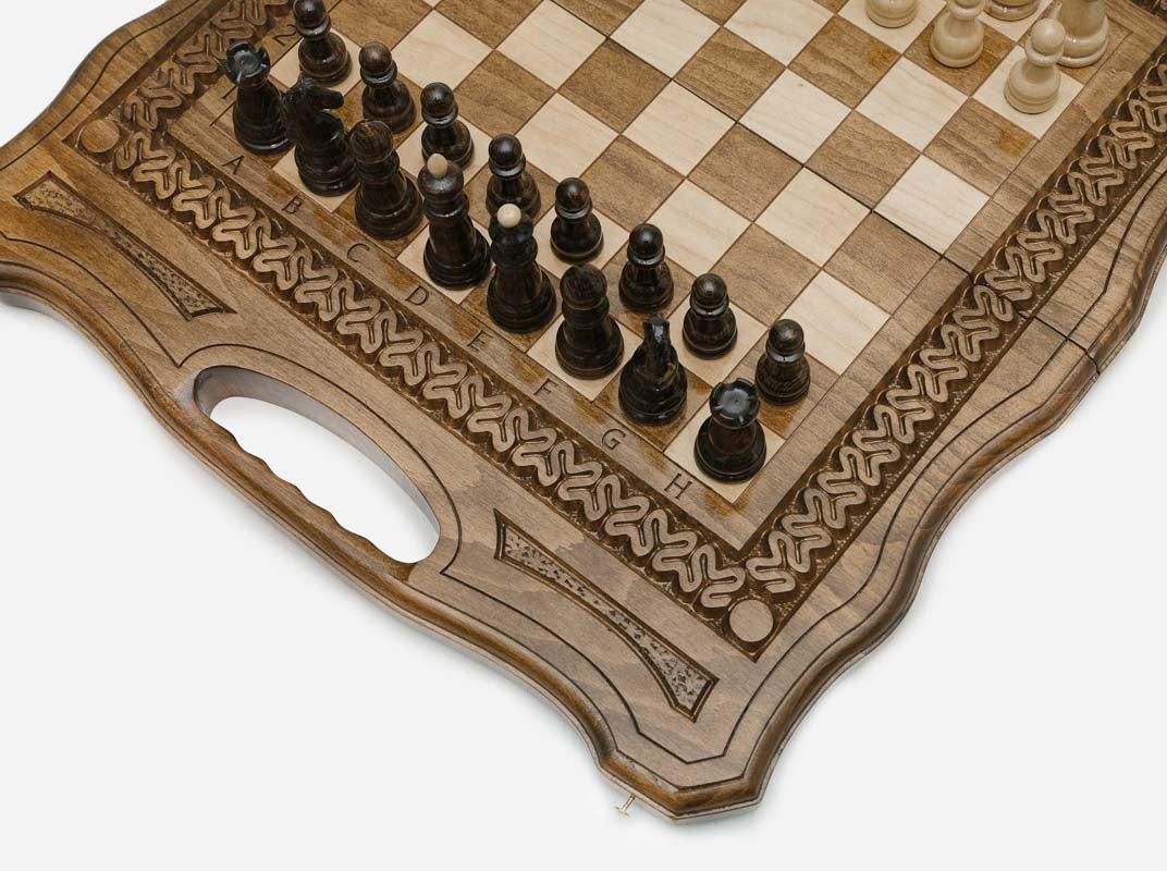 The folding chess board standing open, showing its chess face, rope-carved border and carry-handle cutout