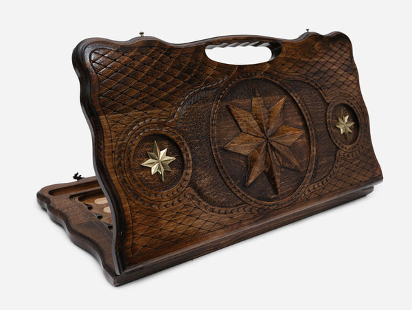 Carved beechwood backgammon board with an octagonal bronze medallion and a carry handle, propped open