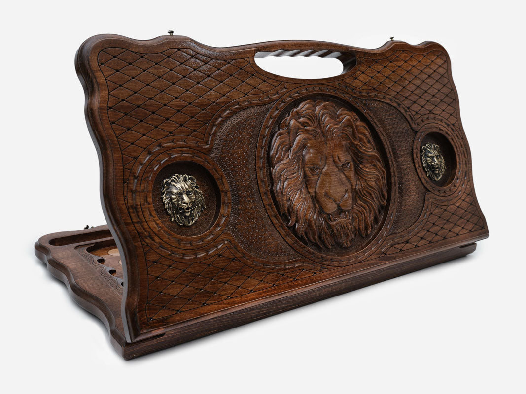 Carved beechwood backgammon board with a lion and bronze lion medallions, with a carry handle, propped open