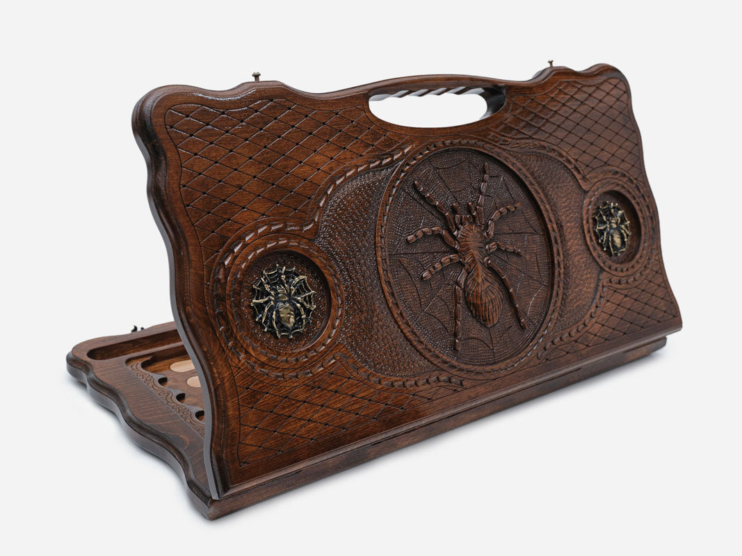 Carved beechwood backgammon board with a spider medallion and bronze accents, with a carry handle, propped open
