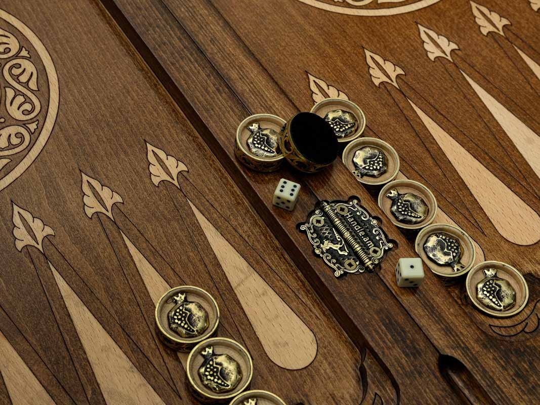 Close-up of the backgammon checkers, dice and cup on the Handle Pomegranate table