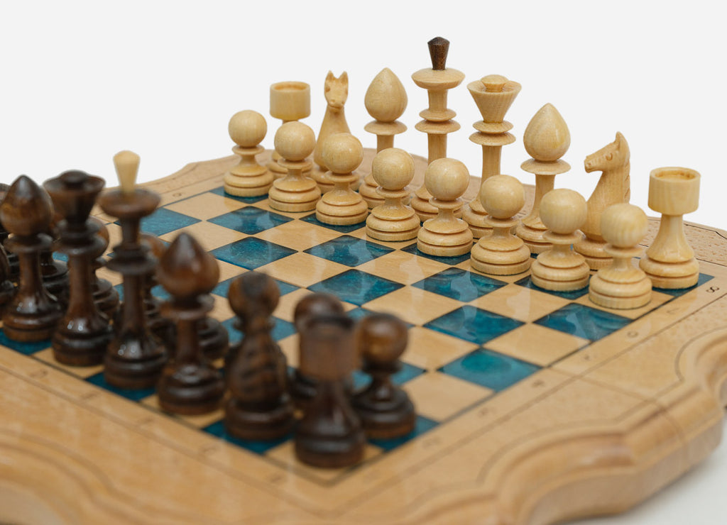 Overhead view of the small blue epoxy chess board with the full set of wooden pieces