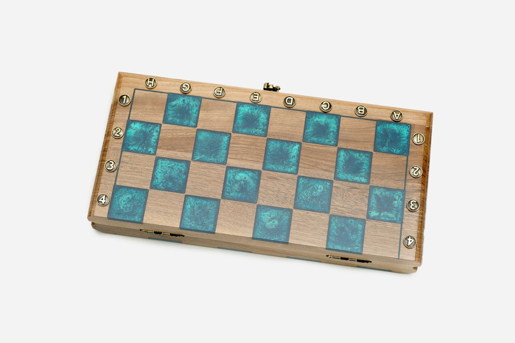 The folding board shown closed with its turquoise epoxy chessboard face