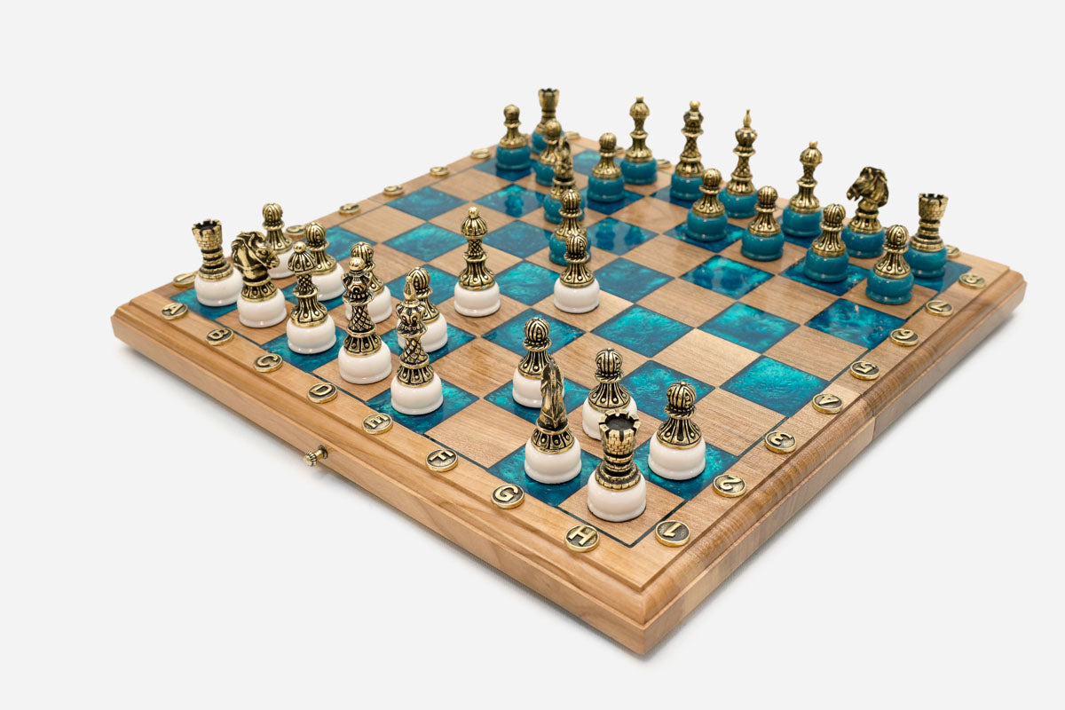 Close-up of the ornate bronze chess pieces on white bases