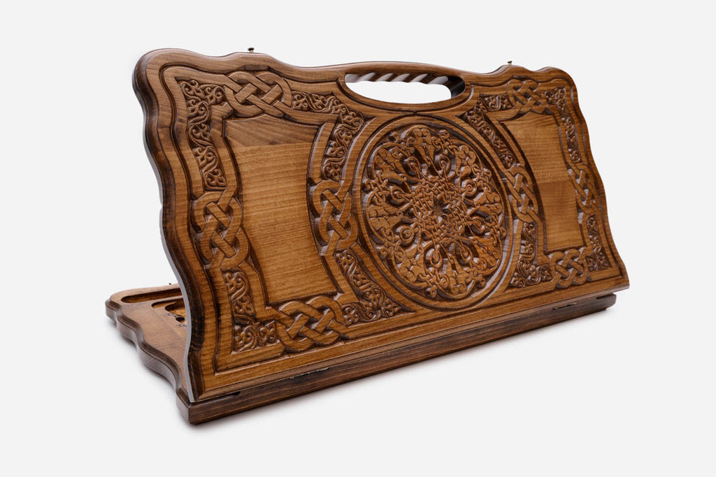 Carved beechwood backgammon board with a bold rosette medallion and knotwork panels, with a carry handle, propped open