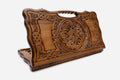 Carved beechwood backgammon board with a bold rosette medallion and knotwork panels, with a carry handle, propped open