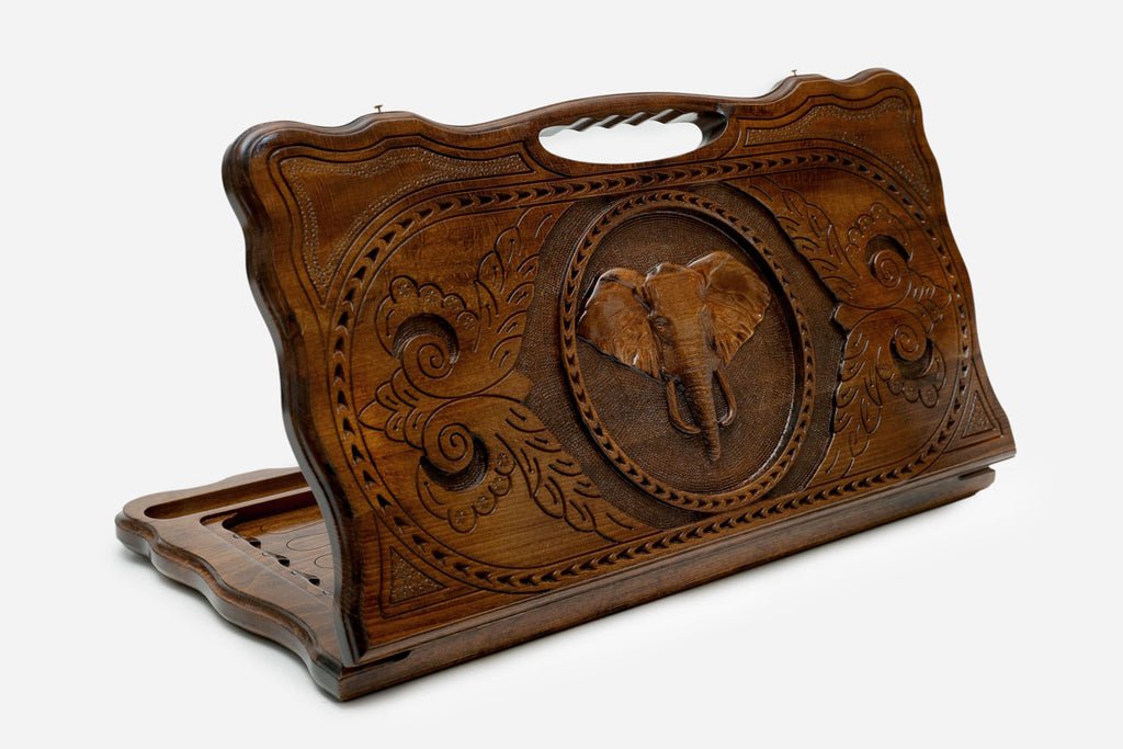 Carved beechwood backgammon board with an elephant medallion and a carry handle, propped open