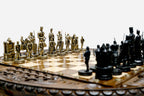 Close-up of the Crusaders chess pieces - a gold-brass army facing a black army of medieval knights, kings and castle rooks on the carved board