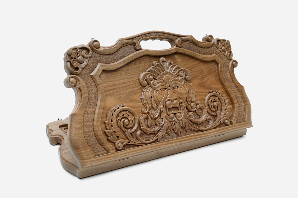 Ornate walnut backgammon board with a master-carved lion in a baroque cartouche and a carry handle, shown propped open