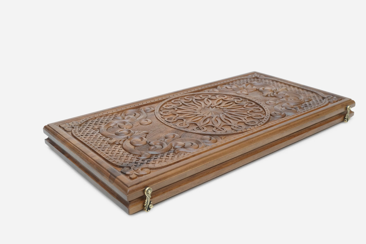 Close-up of an ornamental rosette carving on the walnut board