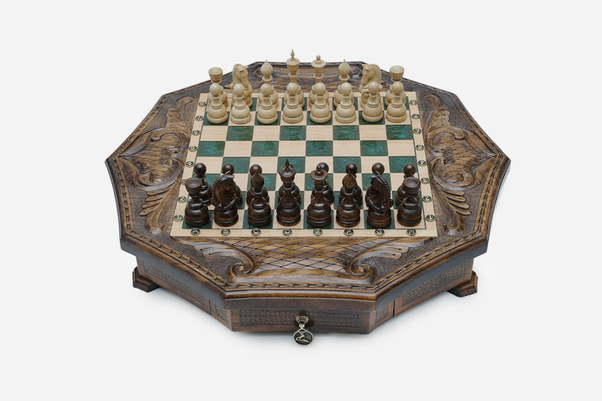 Octagonal carved wooden chess set with emerald-green epoxy squares and wooden Staunton pieces set up for play
