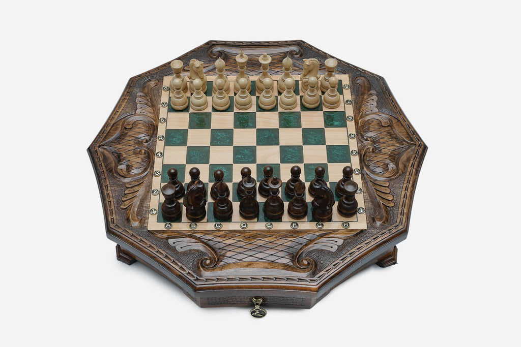 The octagonal chess set with its storage drawer pulled open, revealing black felt lining and a brass pendant pull