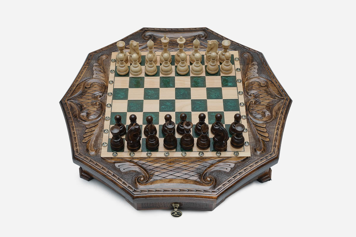 The octagonal chess set with its storage drawer pulled open, revealing black felt lining and a brass pendant pull