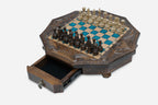 The octagonal chess set with its storage drawer pulled open, revealing black felt lining and a brass pendant pull