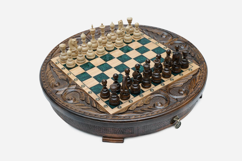 Angled view of the green epoxy chess board with light and dark wood pieces in starting position