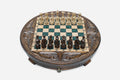 Round carved wooden chess set with emerald-green epoxy resin squares and wooden Staunton pieces arranged for play