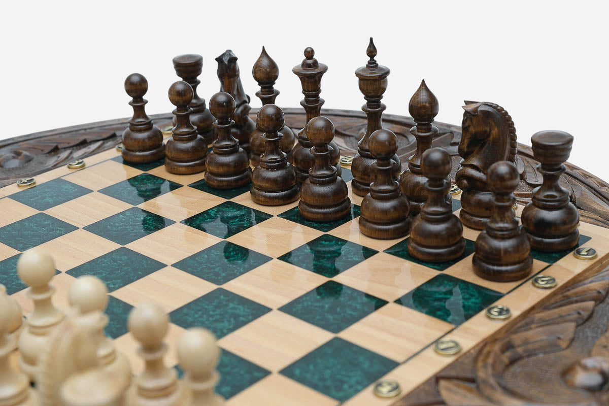 Close-up of the dark walnut chess pieces on the green epoxy board