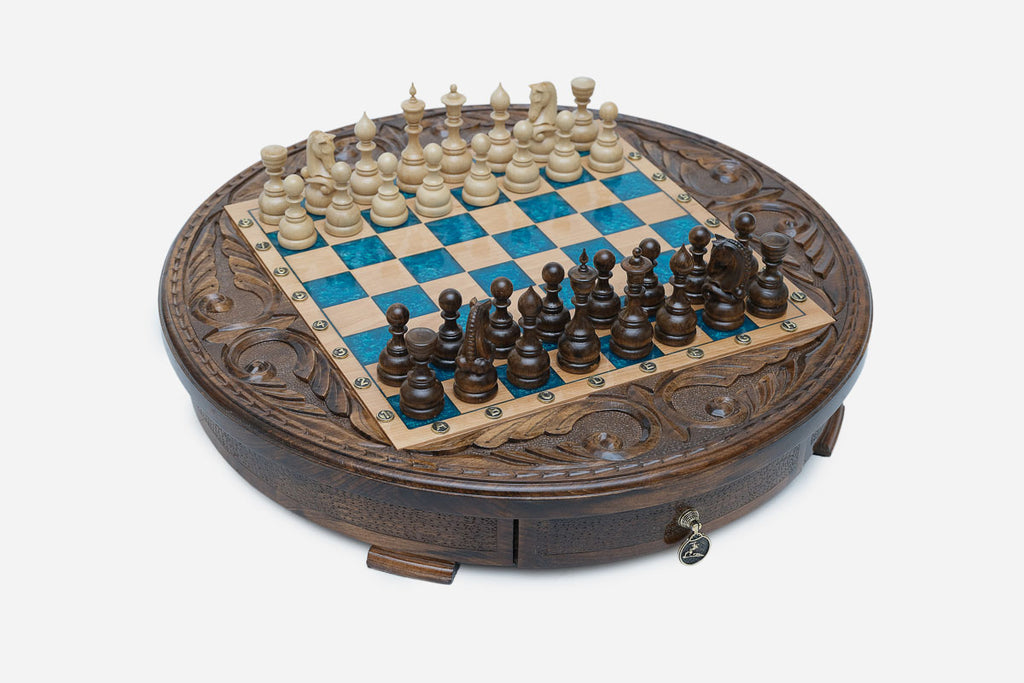 Full view of the round blue-epoxy chess board with light and dark wood pieces in starting position