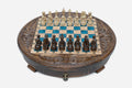 Round carved wooden chess set with turquoise-blue epoxy resin squares and wooden Staunton pieces set up for play
