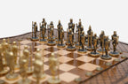 Detail of the ornate cast-metal soldier chess pieces facing off across the diamond-carved board