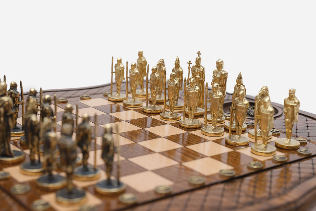 Close-up of the gold and dark bronze figural chess pieces - knights and warriors with spears and shields