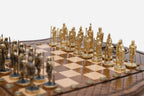 Close-up of the gold and dark bronze figural chess pieces - knights and warriors with spears and shields