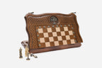 Folding beechwood chess and backgammon set partly closed, shown with its figural metal chess pieces and branded carry bag