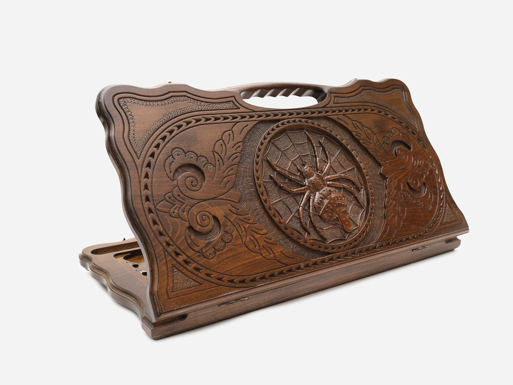 Carved beechwood backgammon board with a spider-and-web medallion and a carry handle, shown propped open