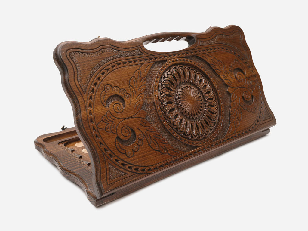 Carved beechwood backgammon board with a central rosette medallion and floral scrollwork, with a carry handle, propped open