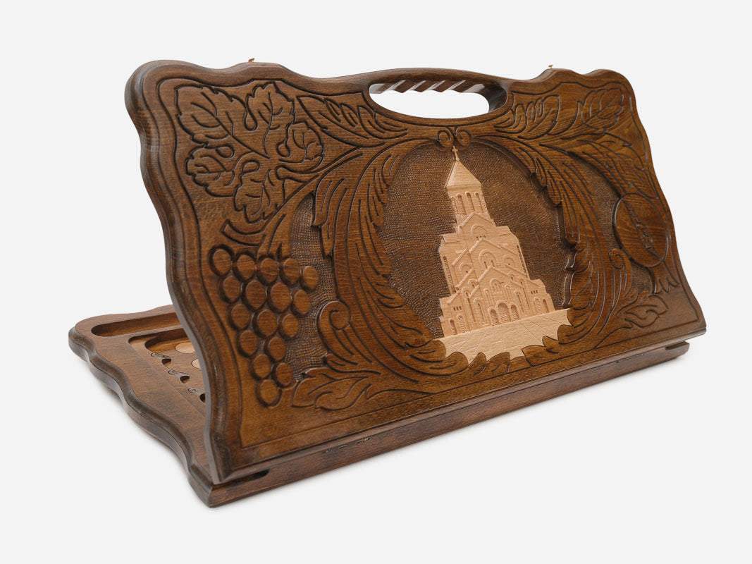 Carved beechwood backgammon board showing the Holy Trinity Cathedral of Tbilisi in grapevines, with a carry handle, propped open