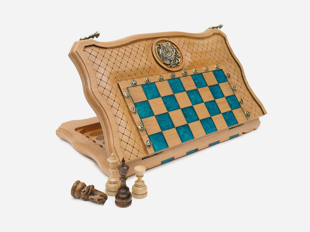 Folding pale-wood chess board with turquoise epoxy squares, an inlaid coat-of-arms medallion and wooden pieces, standing partly open