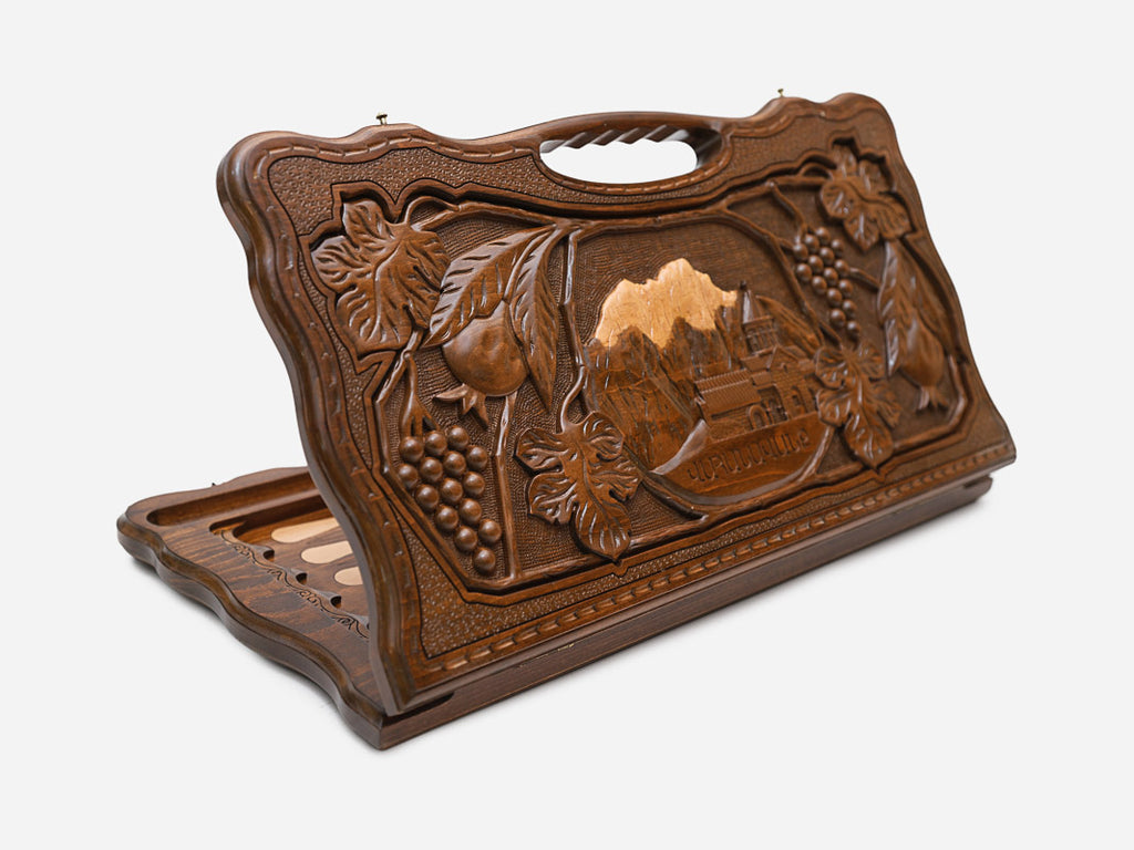 Carved beechwood backgammon board depicting the Vahanavank monastery among mountains and grapevines, shown propped open
