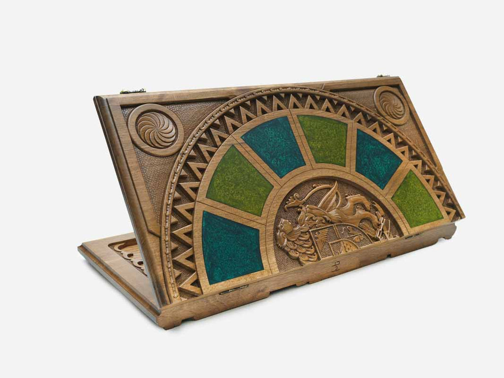 Folding walnut backgammon board standing open, with green and teal epoxy panels fanned around a carved Armenian coat-of-arms medallion