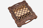 Close-up of the ornate bronze chess pieces on cream bases