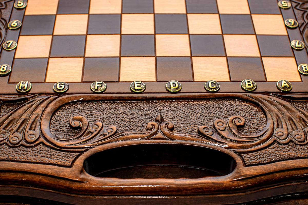 Close-up of the carved border, bronze coordinate markers and carry-handle cutout