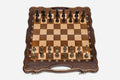 Folding walnut chess board with carved corners and ornate bronze figural pieces - dark and gold armies in starting position