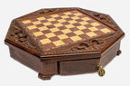 Angled view of the empty octagonal chess board with carved fleur-de-lis border and brass drawer pendant