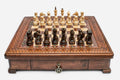 Square wooden chess set with carved diamond-lattice border and Staunton pieces set up on the walnut and maple board